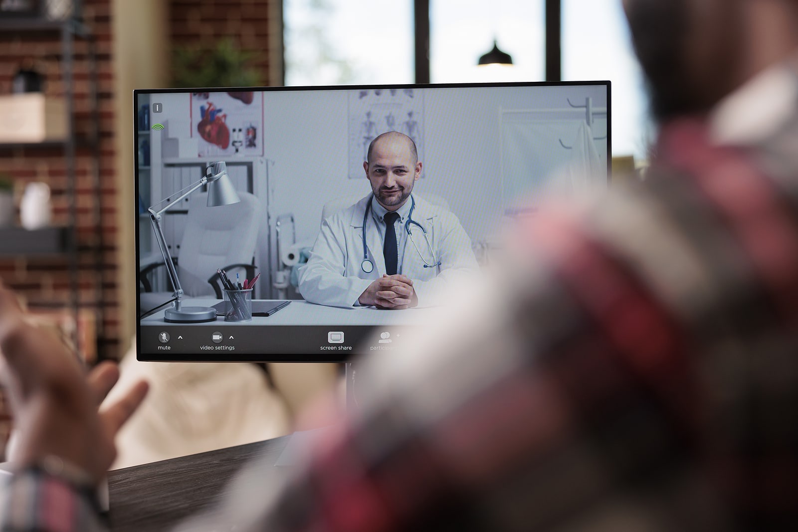 Male patient talking to doctor in telehealth appointment
